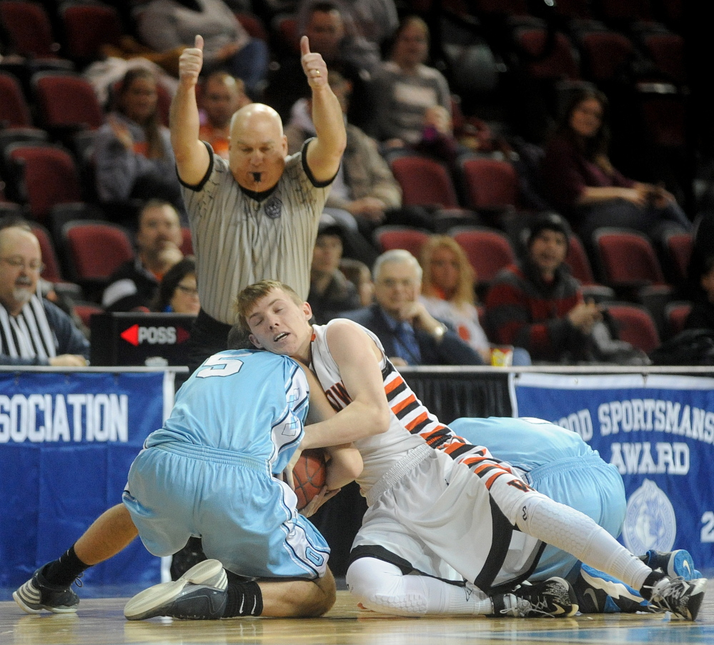 Winslow’s Colby Robertson, 1, battles for the loose ball with Oceanside’s Nate Raye in the first half of Saturday’s Eastern Class B boys’ basketball quarterfinal at Bangor. Winslow won, 46-40.