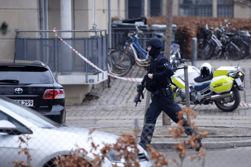 An armed security officer runs down a street near a venue after shots were fired where an event titled  “Art, blasphemy and the freedom of expression” was being held in Copenhagen on Saturday.