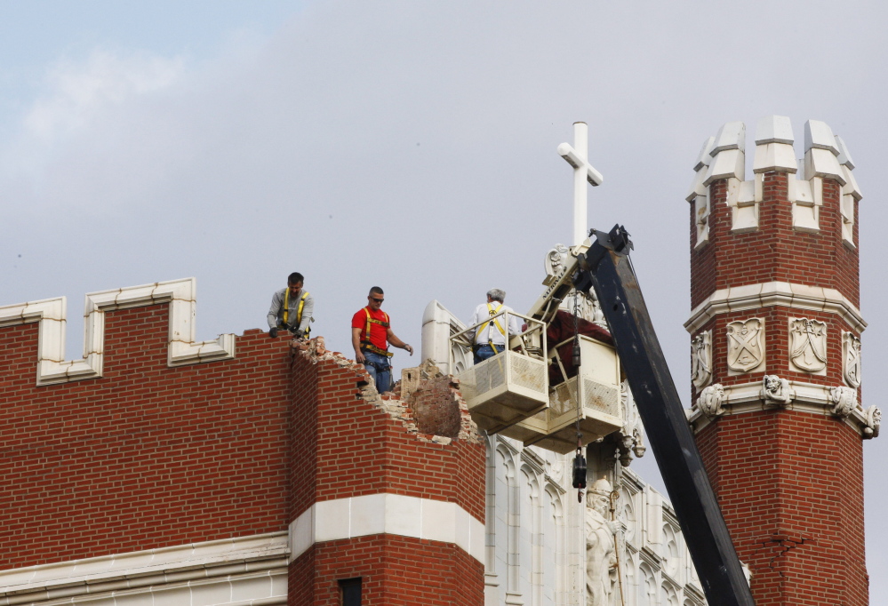 Maintenance workers inspect the damage to one of the spires on Benedictine Hall at St. Gregory’s University in Shawnee, Okla., after two earthquakes hit the area in less than 24 hours.  New federal research says small earthquakes shaking Oklahoma and southern Kansas daily are dramatically increasing the chance of bigger and dangerous quakes, new federal research indicates.