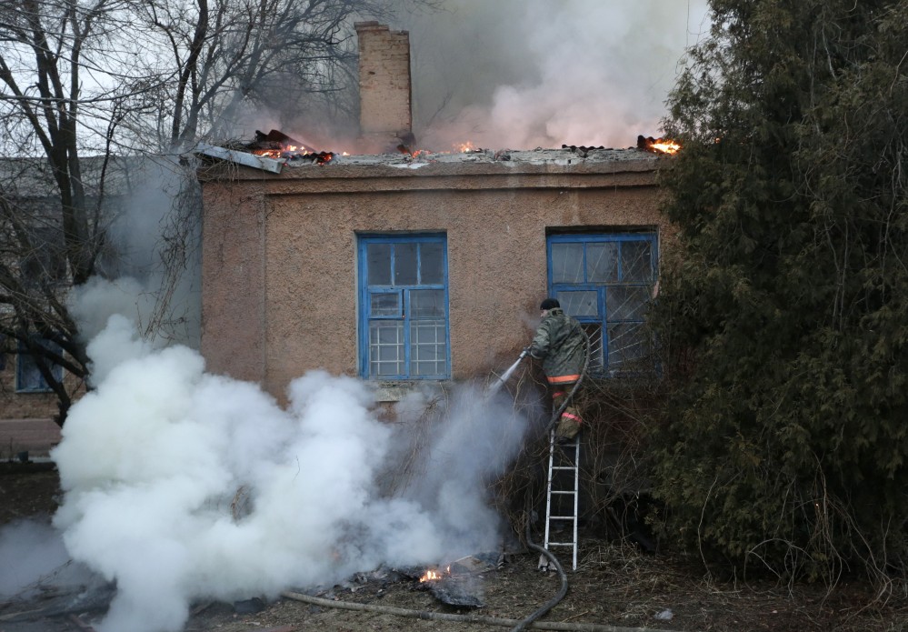 A firefighter tries to extinguish a building fire after shelling Saturday between Russian-backed separatists and Ukrainian troops in Artemivsk, Ukraine.