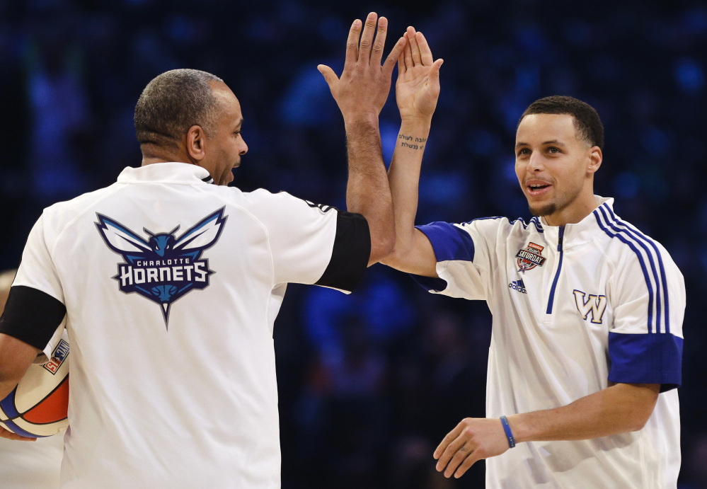 Golden State Warriors’ Stephen Curry celebrates with his father, Dell Curry, left, during the NBA All-Star Saturday Shooting Stars event in New York.  Curry won the 3-point shooting contest.