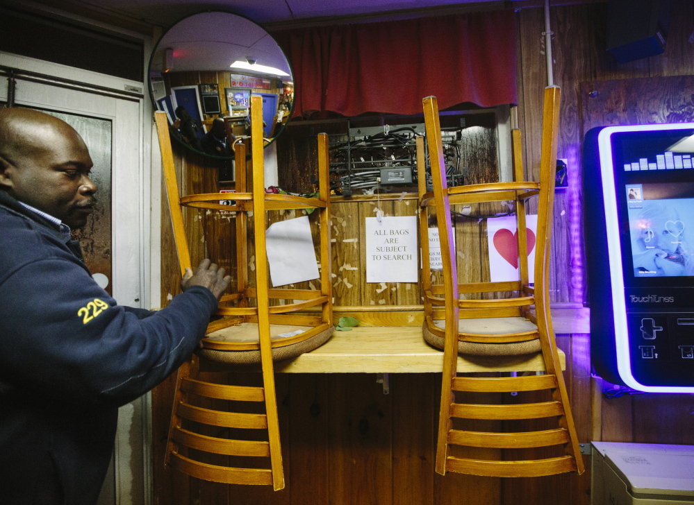 Doorman Emerson Boxill puts chairs up so the floor can be cleaned after Sangillo’s last day on Saturday.