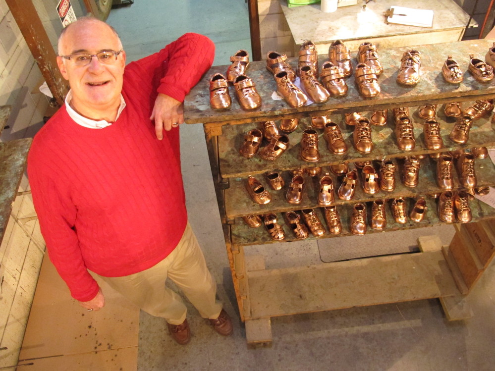 Robert Kaynes, CEO of American Bronzing Co., shows off some of the 100 pairs of baby shoes his company bronzes daily, down from 2,000 pairs in the ‘70s. But sales are climbing.