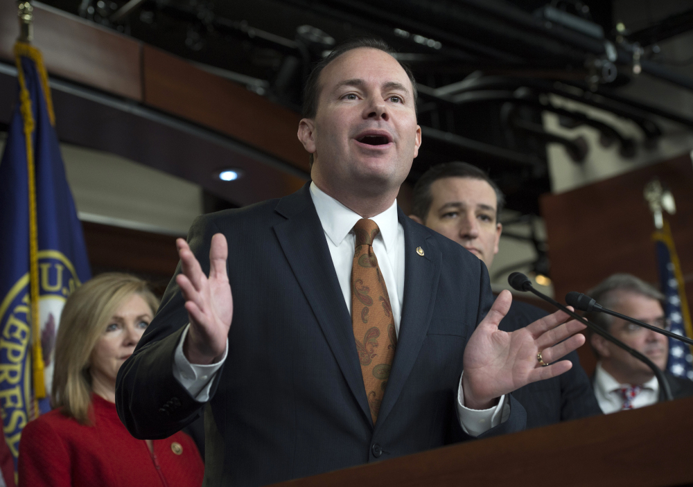 Sen. Mike Lee, R-Utah, center, flanked by  Rep. Marsha Blackburn, R-Tenn., left, and Sen. Ted Cruz, R-Texas, gestures during a news conference on Capitol Hill in Washington, Thursday to discuss  the Department of Homeland Security funding bill.