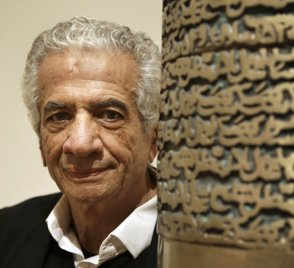 Iranian artist Parviz Tanavoli stands near a detail of his sculpture, “Poet Turning Into Heech.” Heech means “nothing” in Persian.