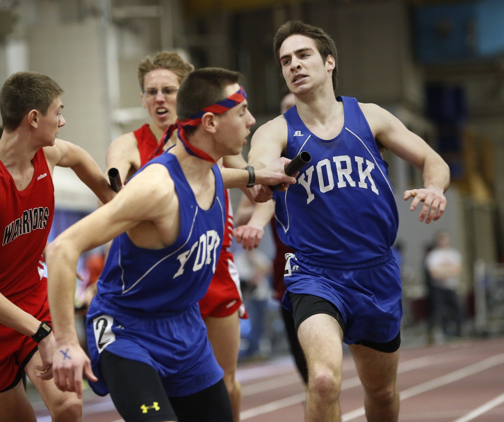Schaeffer Rees of York hands the baton to teammate Nate Bald after the first leg of the 4x800-meter relay Monday at the Class B indoor track and field championships in Lewiston. York won the overall team championship for the third time in four years.