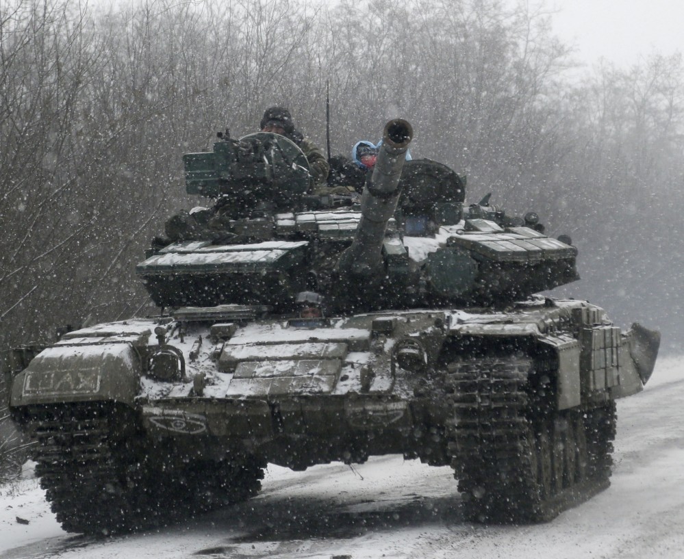 A Ukrainian armored vehicle drives on the road between the towns of Debaltseve and Artemivsk, Ukraine, Monday, Feb. 16, 2015. The Ukrainian government and Russia-backed rebels accused each other Monday of violating a cease-fire in eastern Ukraine, a day before the parties are due to start withdrawing heavy weaponry under a recently brokered deal. The cease-fire, which went into effect on Sunday, had raised cautious hopes for an end to the 10-month-old conflict, which has already claimed more than 5,300 lives. (AP Photo/Petr David Josek)