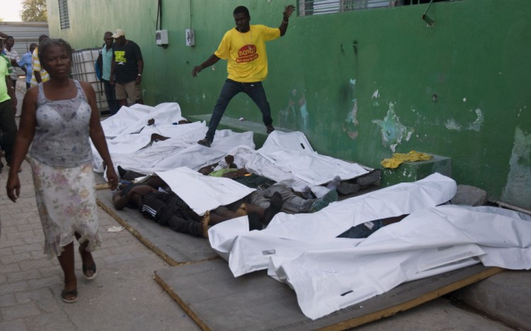 A woman walks away from bodies after failing to find a missing family member among them outside the morgue at the General Hospital in Port-au-Prince, Haiti, Tuesday.