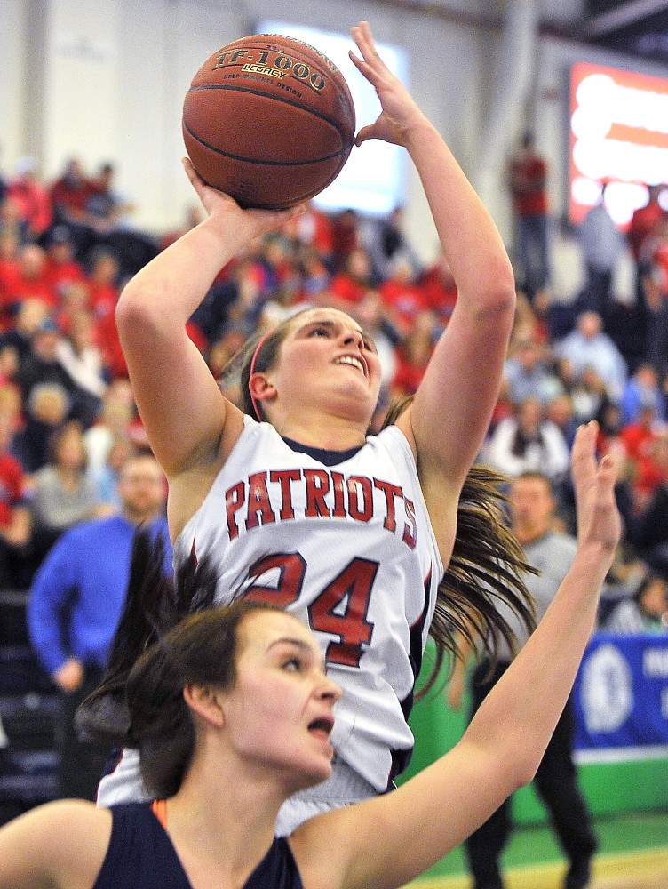 PORTLAND, ME - FEBRUARY 17: GNG #24, Maria Valente gets a shot off over the Poland defense as Gray-New Gloucester plays Poland in Class B West quarter-finals in the Maine High School Invitational Basketball Tournament at the Portland Expo. (Photo by Gordon Chibroski/Staff Photographer)