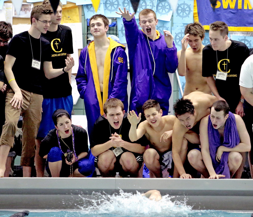 Members of the Cheverus swim team cheer on teammate Gustav Anderson in the 100-yard breast stroke during the Class A boys’ swimming and diving state championships Wednesday at Bowdoin College. Cheverus won the team title for the third year in a row.