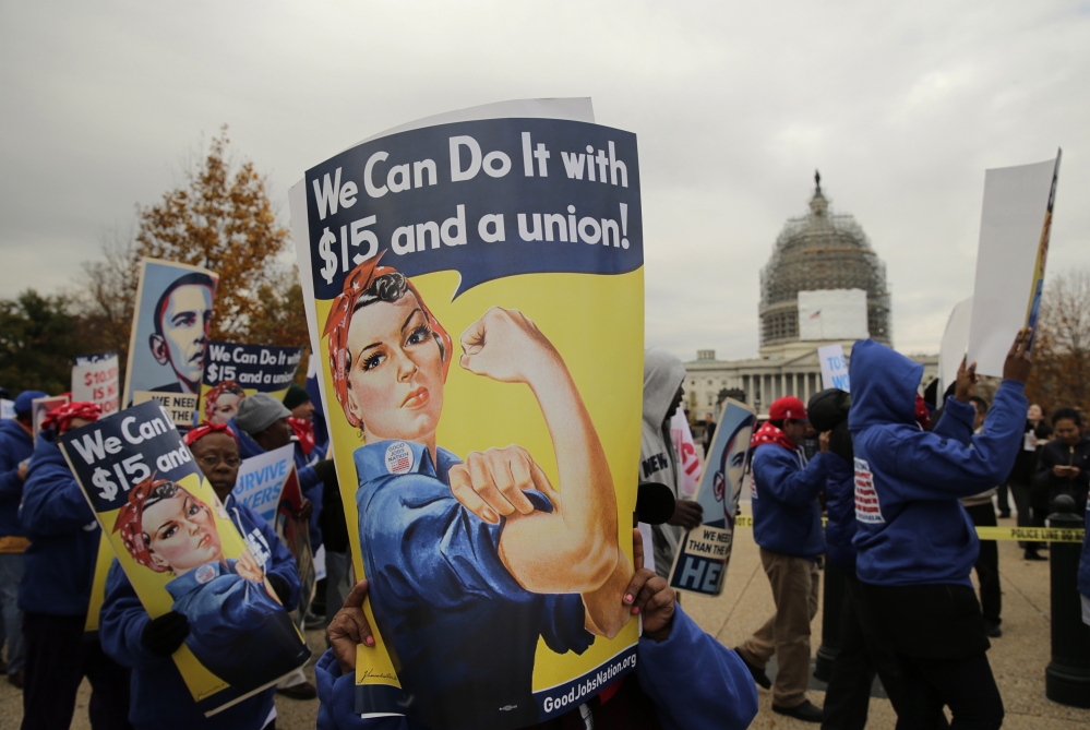People rally for a higher minimum wage in Washington in November.  But raising the minimum wage is turning out to be only a slight help for lowest-paid workers.