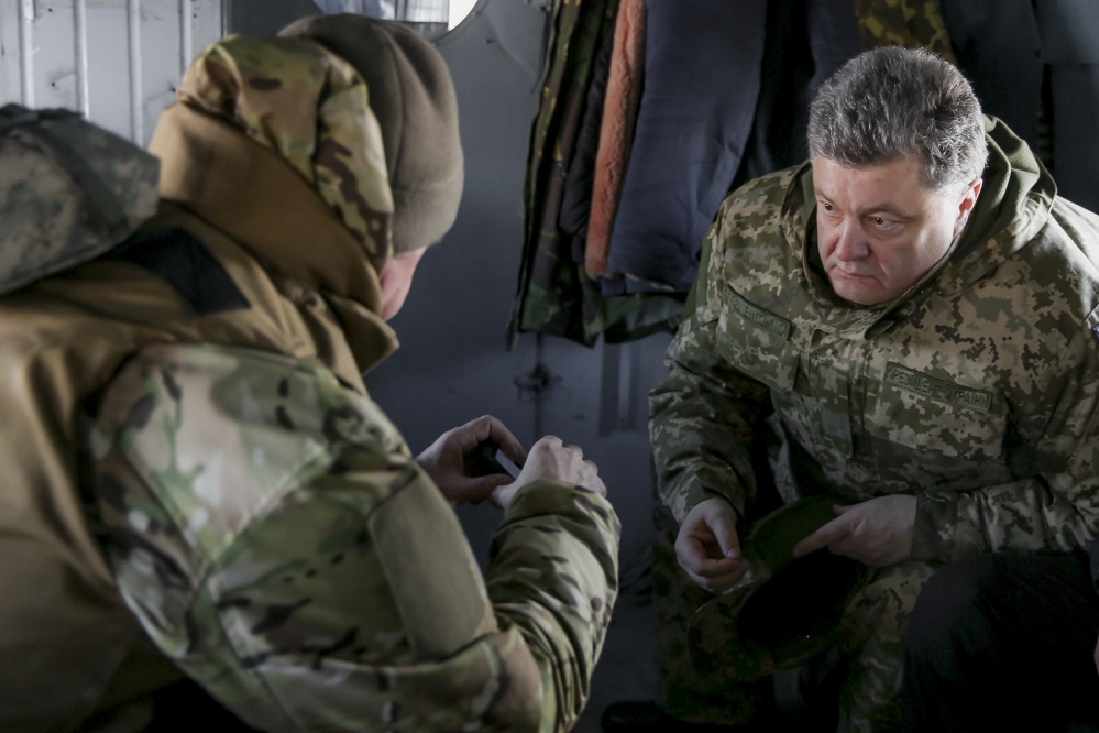 Ukrainian President Petro Poroshenko, right, speaks with a Ukrainian soldier in Artemivsk, Ukraine, Wednesday. He has called for help from an international peacekeeping mission.