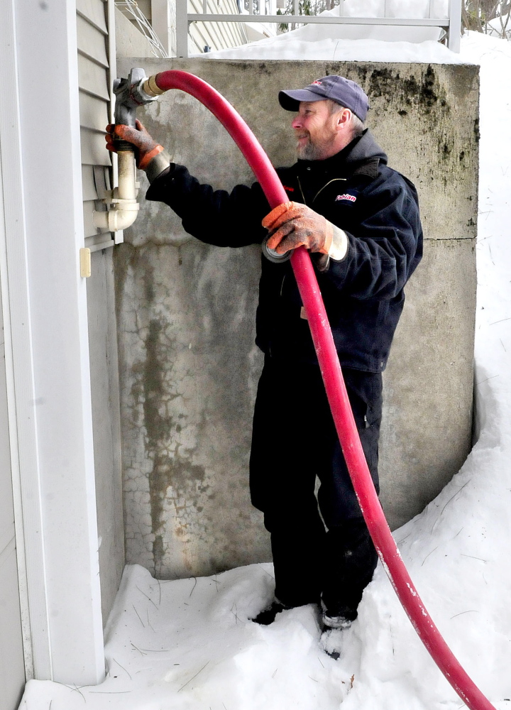 Kevin Keniston of Fabion Oil fills a tank with No. 2 heating oil Tuesday at a residence in Waterville.