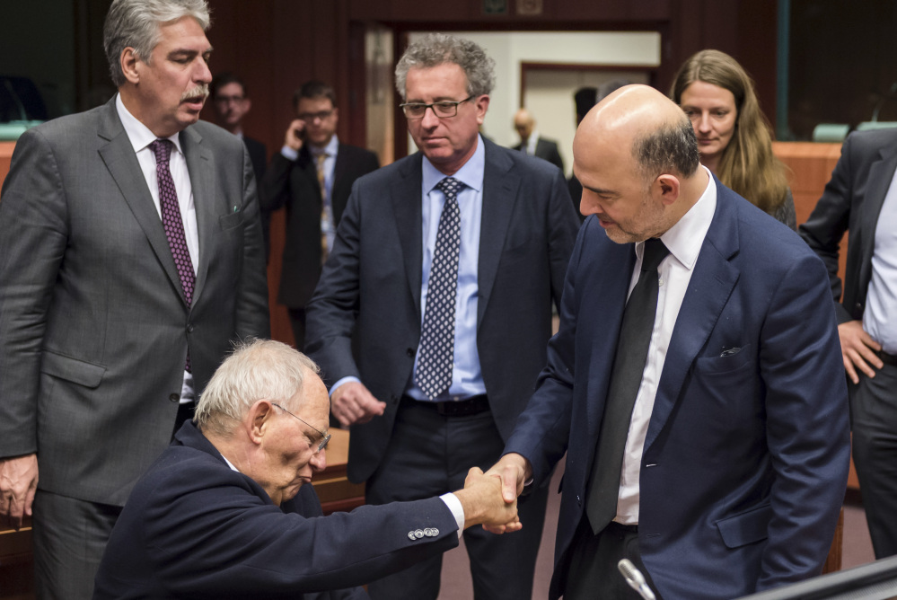 European Union Commissioner for Monetary Affairs Pierre Moscovici, right, shakes hands with German Finance Minister Wolfgang Schaeuble during a roundtable meeting of eurogroup finance ministers in Brussels on Friday.
