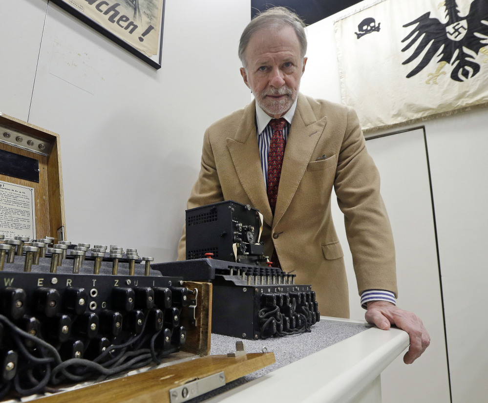 Kenneth Rendell poses Wednesday with Nazi Enigma encryption machines at his World War II Museum in Natick, Mass. The museum has more than any entity but the NSA.