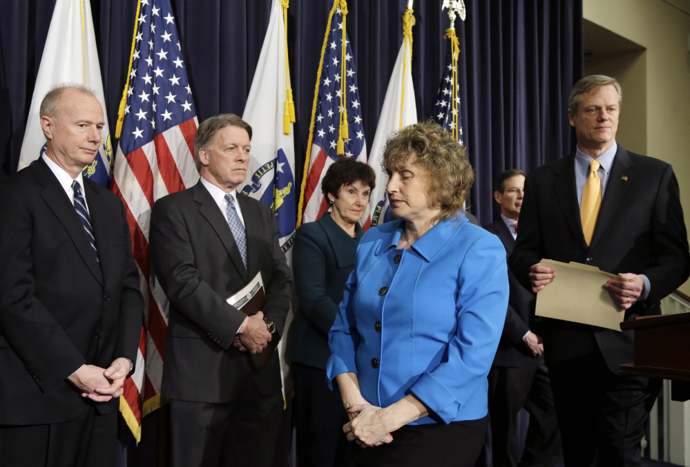 Gov. Charlie Baker, right, steps back to the podium after Stephanie Pollack, state secretary of transportation, center, spoke at a news conference in Boston on Friday. Baker said a panel of experts will review the transit system in depth.