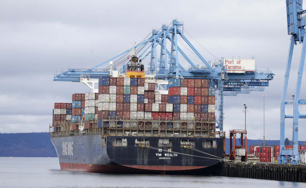 A cargo container ship sits docked at the Port of Tacoma, Washington, on Friday. With ships and their cargo weeks behind schedule, dockworkers and their employers reached a tentative agreement on a new contract late Friday.