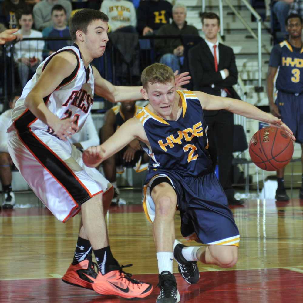 Hyde senior guard Keifer Cundy tries to dribble past Aaron Moffitt of Forest Hills, which beat the Phoenix to remain unbeaten and advance to the Class D state championship game.