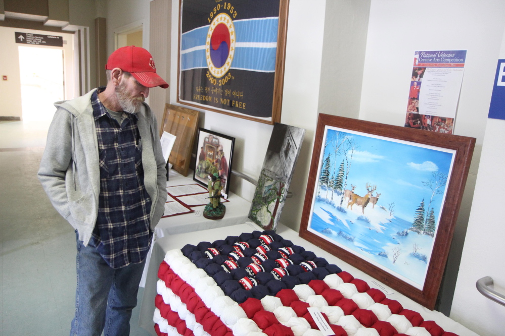 Rodger Sweeney of Exeter, looks at artwork Saturday at the 2015 Maine Veterans Creative Arts Festival.