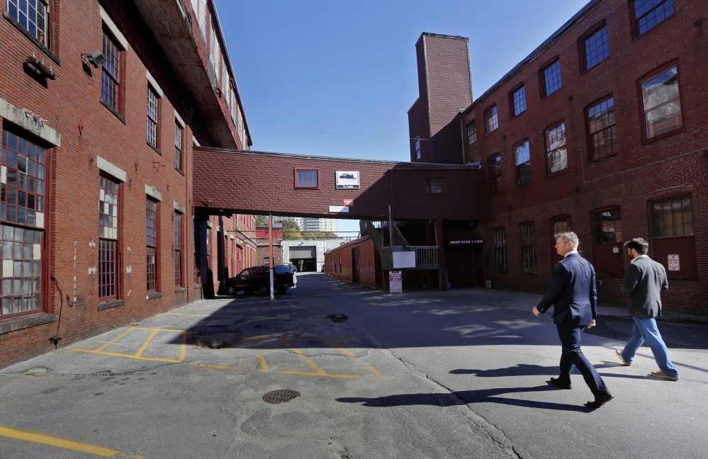 James Brady, left, and Casey Prentice, owners of the former Portland Co. complex, walk around the site in October. 