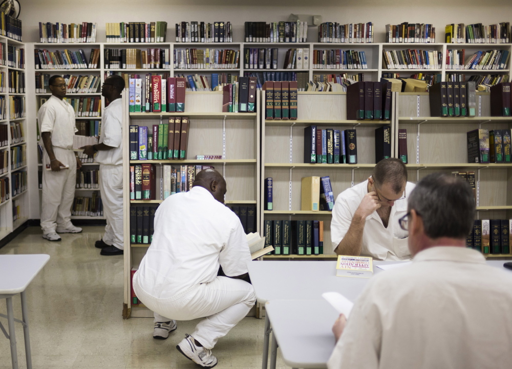 Inmates use the library at the men’s prison in Rosharon, Texas. Several states rely on surveys to assess the risk of repeat offenses.