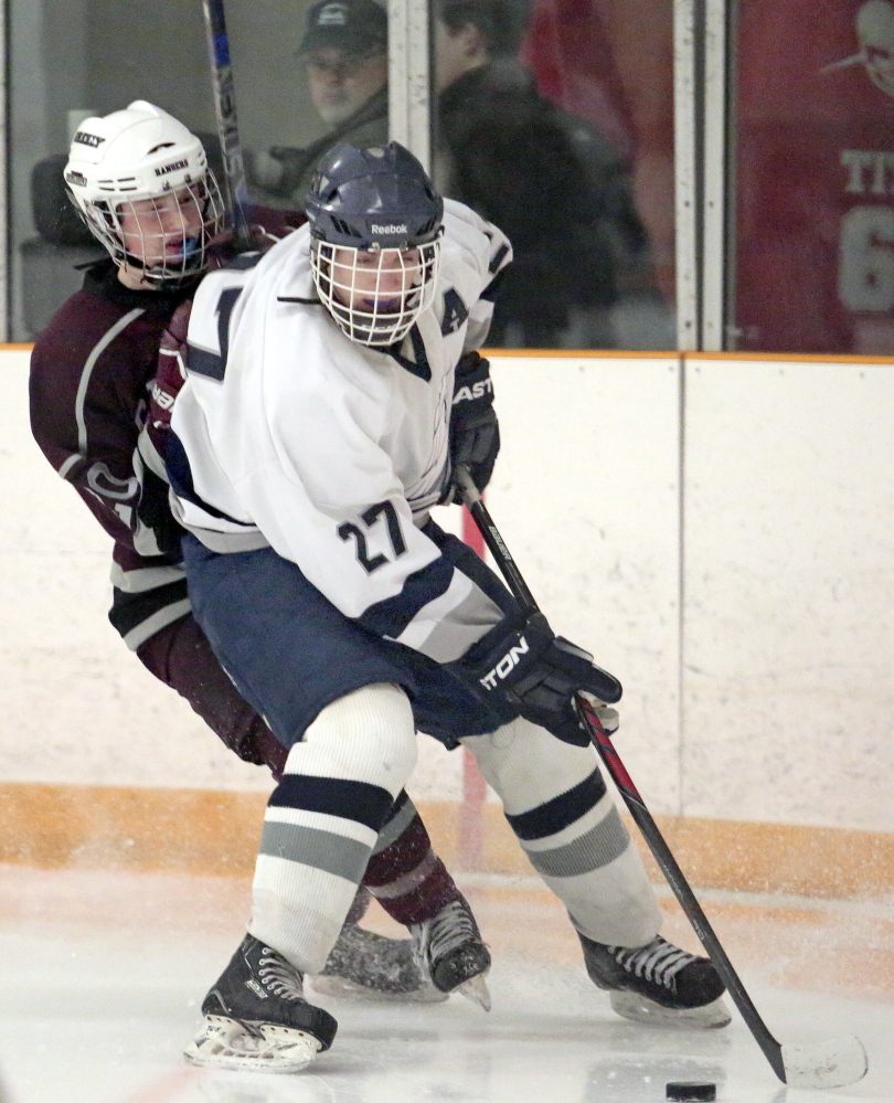 Yarmouth’s Walter Conrad fends off Greely’s Colby Williams in a Western Class B quarterfinal Tuesday night at the Travis Roy Arena in Yarmouth. Conrad had a goal and an assists in Yarmouth’s 4-2.