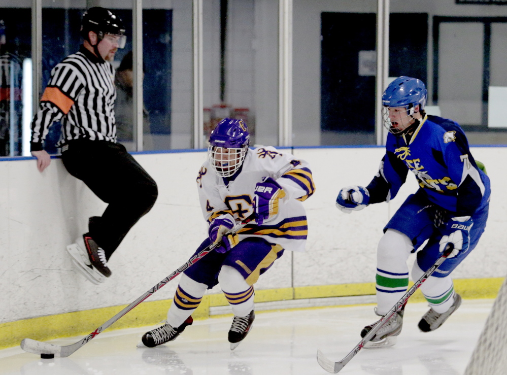 Jesse Cyr-Brophy of Cheverus skates with the puck while being chased by Gabe Sappington of Lake Region/Fryeburg/Oxford Hills in Wednesday’s Western Class A quarterfinal won by the Stags 12-1 at Troubh Ice Arena in Portland.