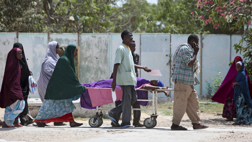 Relatives help a woman who was wounded during a mortar attack on the presidential palace, as she is moved on a stretcher to a hospital in the capital Mogadishu, Somalia Thursday, Feb. 26, 2015. A Somali police officer says that at least three mortars landed inside Somalia’s heavily fortified presidential palace compound, with al-Shabab claiming responsibility for the shelling, according the group’s radio station, Andulus.