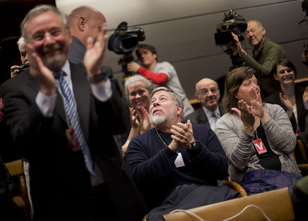 Apple co-founder Steve Wozniak, center, and his wife Janet Hill, right, joins members of the audience in applauding at an open hearing at the Federal Communications Commission in Washington on Thursday. The FCC voted in favor of rules aimed at enforcing what’s called “net neutrality.”