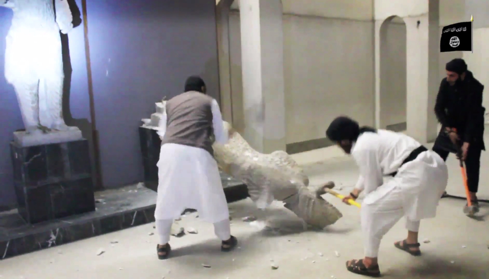 Militants take sledgehammers to an ancient artifact in the Ninevah Museum in Mosul, Iraq. The militants are also believed to have sold ancient artifacts on the black market to finance their bloody campaign.