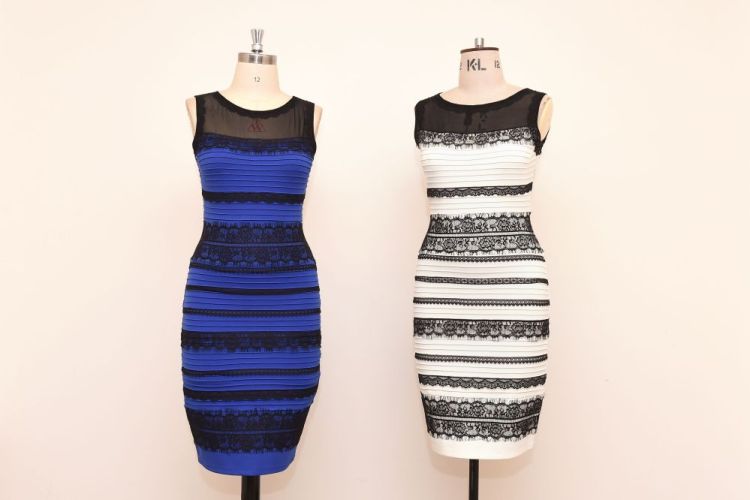 The royal blue and black dress, left,  alongside an ivory and black version, made by Roman Originals, that has sparked a global debate on Twitter over its true colour is on display in Birmingham, England, on Friday.