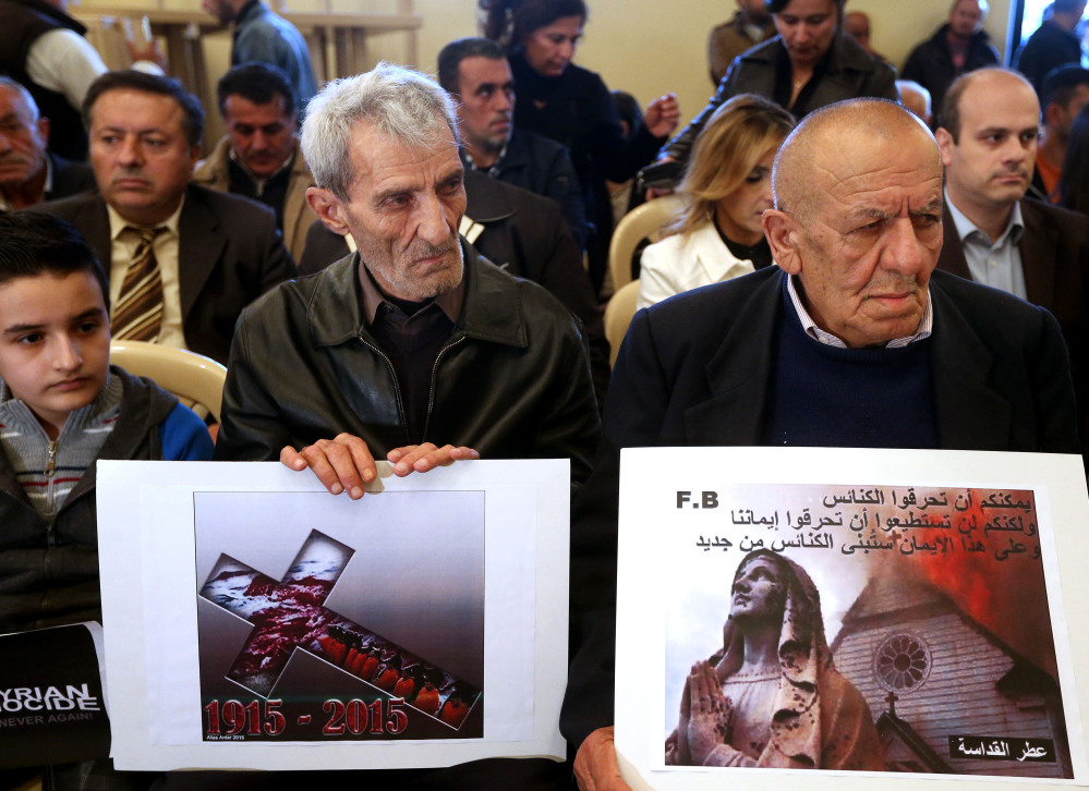 Assyrian citizens hold placards during a sit-in in Beirut for abducted Christians in Syria and Iraq. The placard at right reads, “You can burn the churches but you cannot burn our faiths, and in this faith we will rebuild the churches.”
