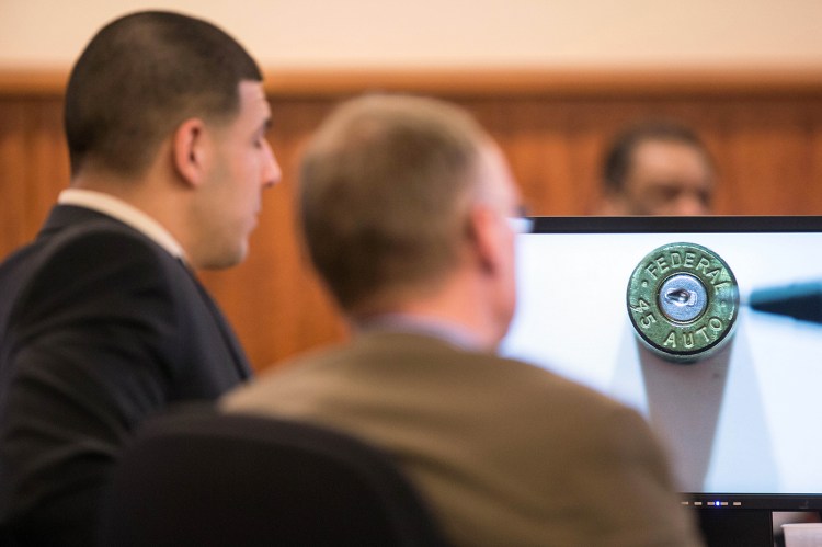 A bullet casing found at the murder scene is displayed as evidence in front of former New England Patriots football player Aaron Hernandez during his murder trial at Bristol County Superior Court in Fall River, Mass., on Wednesday. Hernandez is accused of killing Odin Lloyd in June 2013.  The Associated Press