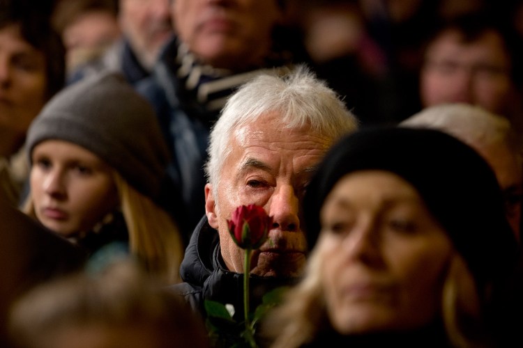 People gather during a  vigil in honor of the two men killed by a gunman over the weekend, at Oesterbro, near the Teater Building 'Krudttonden', the scene of the first attack in Copenhagen, Denmark.