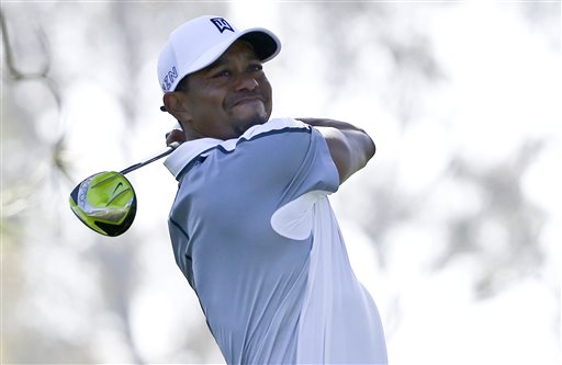 Tiger Woods watches his tee shot head far to the right on the 11th hole at Torrey Pines in San Diego during the first round of the Farmers Insurance Open golf tournament Thursday. He left the tournament with a stiff back. The Associated Press
