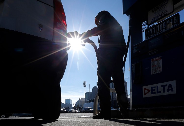 Sonu Singh pumps gas for a motorist at a gas station in downtown Newark, N.J., where the cash price for regular unleaded was listed at $1.71 on  Jan. 23. The Associated Press