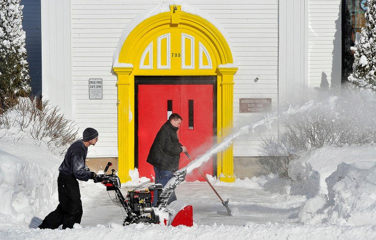 FEB. 3: Rodney Burns, facilities director for My Place Teen Center in Westbrook, uses a snowblower to clear snow Tuesday morning with the help of youth worker Anthony Moore.  Gordon Chibroski / Staff Photographer