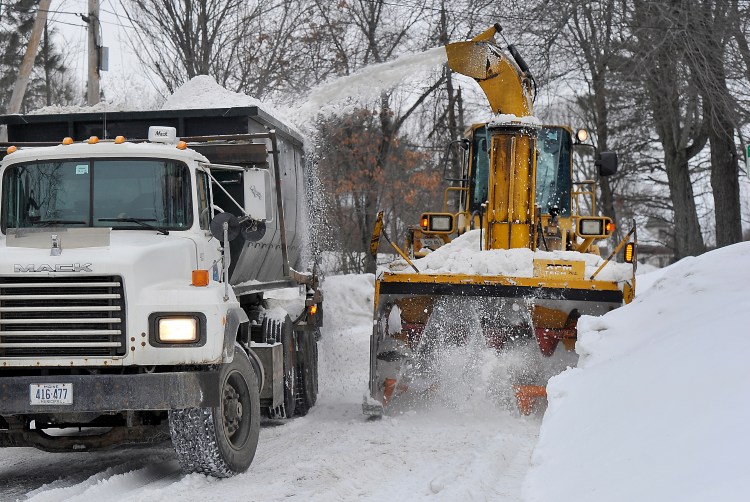 Portland City Services crews remove the heavy accumulation of snowbanks on Washburn Street Thursday morning.
