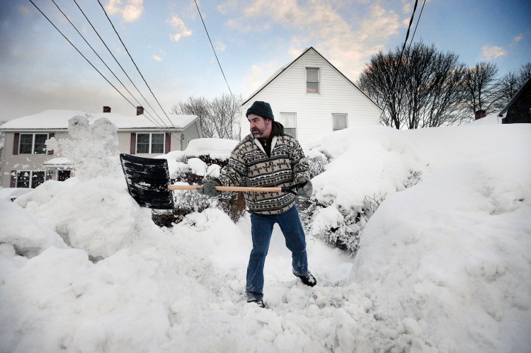 Sean Gallagher shovels a path in front of his High Street home in Saco on Thursday morning.