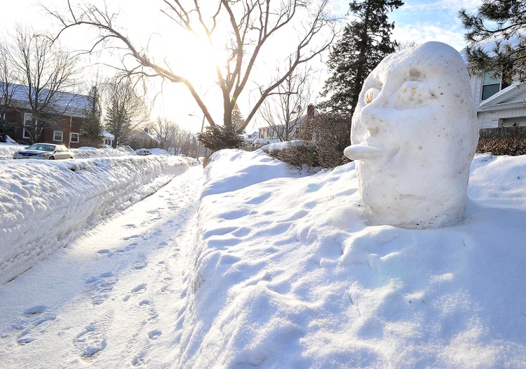 A snow sculpture at the corner of Mitchell and Hillside in South Portland reflects its neighbors' opinions of the winter weather as the sun rises on March 2, 2015, after yet another overnight snowfall.