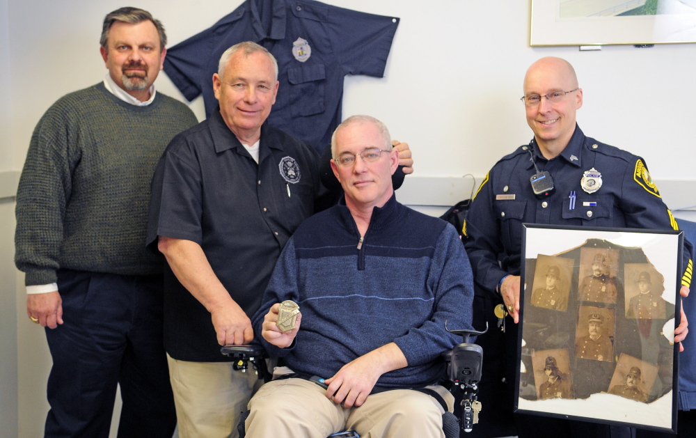 Keith Bushey, second from left, gave the Augusta Police Department an old city marshal’s badge, held by Chief Robert Gregoire, third from left, on Wednesday. Also in the photo are David Allen, far left, and Augusta police Sgt. Christian Behr.