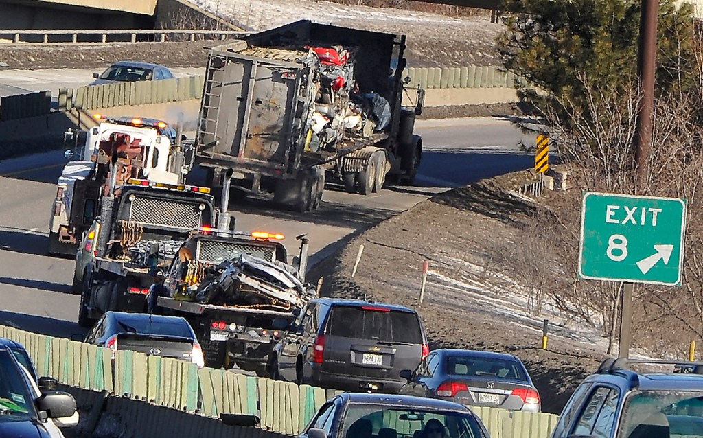 Traffic backed up for miles Friday morning after a tractor-trailer hauling crushed cars spilled part of its load onto Interstate 295 in Portland. The truck is seen here leaving the scene after the flattened cars were loaded onto two flatbed trucks following the carrier.