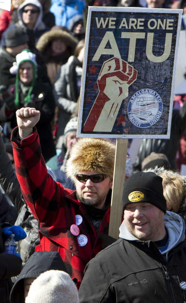 Marc LeClair of Wausau, Wis., with sign, marches against a “right-to-work” proposal on Saturday.