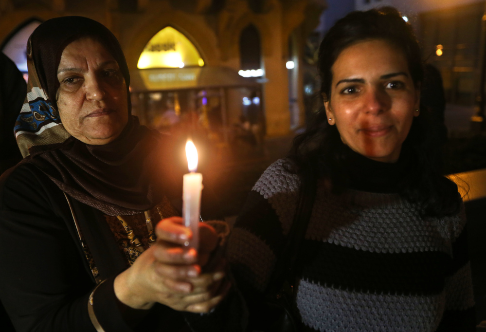 Palestinian women hold candles during a vigil held by a Palestinian group in solidarity with Christians abducted in Syria and Iraq, in downtown Beirut, Lebanon Sunday.