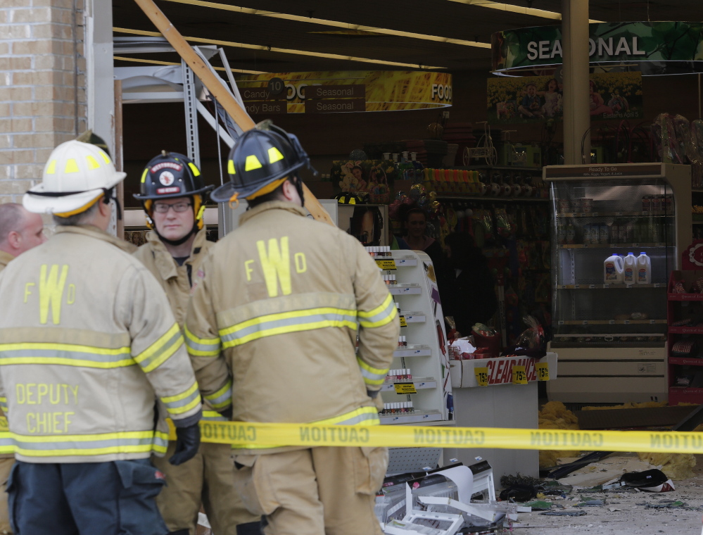 Firefighters secure the scene of an accident on Main Street in Westbrook Sunday involving a vehicle that crashed through the storefront of the Rite Aid.