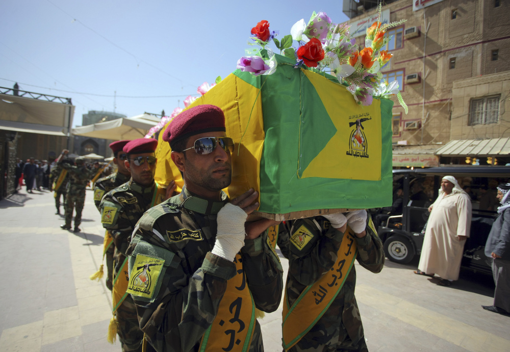 Iraqi Hezbollah fighters carry the coffin of their comrade Ali Mansour, who his family says was killed in Tikrit fighting Islamic militants, during his funeral procession Monday in Najaf.