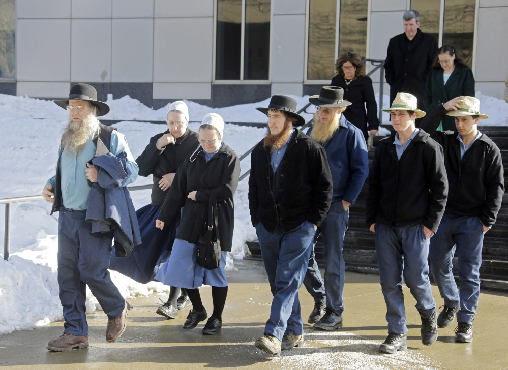 Members of an Amish community in Bergholz, Ohio, leave federal court in Cleveland after a hearing Monday. Sentences were reduced Monday for Sam Mullett, the leader of a breakaway group, and seven of his imprisoned followers who chopped off the hair and beards of Amish people with whom they disagreed.