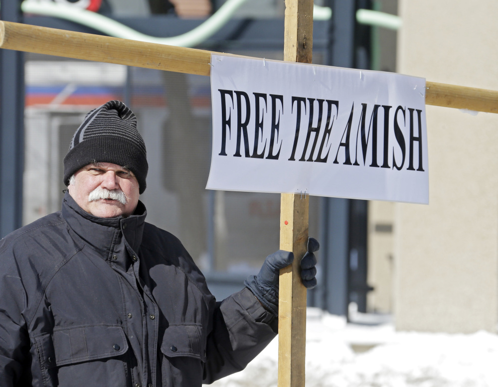 Werner Lange holds a sign outside federal court in Cleveland on Monday. Sixteen Amish men and women were resentenced after a federal appeals court last year dismissed all of their hate crimes convictions in the 2011 attacks in which they chopped off the beards and hair of others with whom they disagreed.