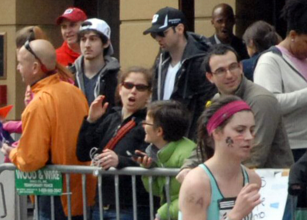 Dzhokhar Tsarnaev, second from left, and Tamerlan Tsarnaev, center, stand in the crowd as Boston Marathon runners headed to the finish line on Boylston Street in Boston on April 15, 2013.
