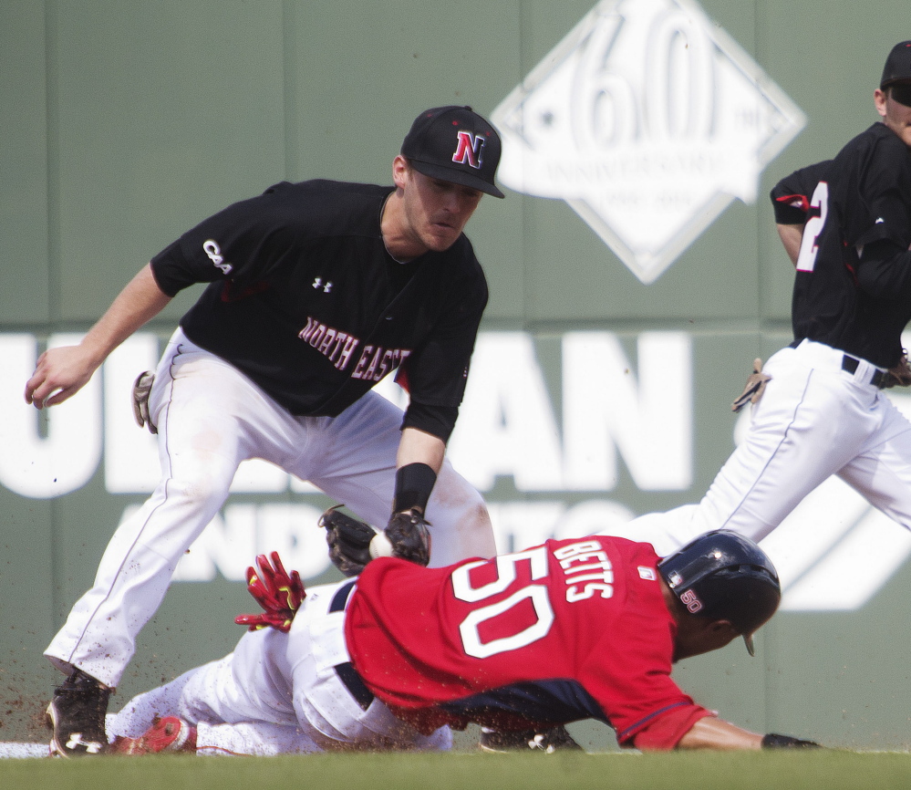 Mookie Betts of the Boston Red Sox is tagged out by Northeastern second baseman Keith Kelly while trying to steal Tuesday during Boston’s 2-1 victory.